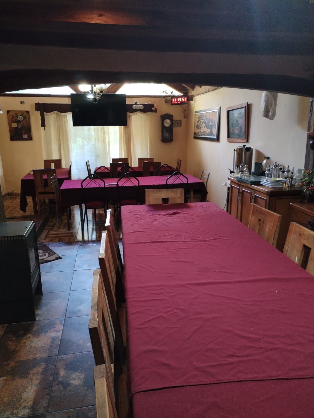 Un comedor con mesas y sillas y un televisor.