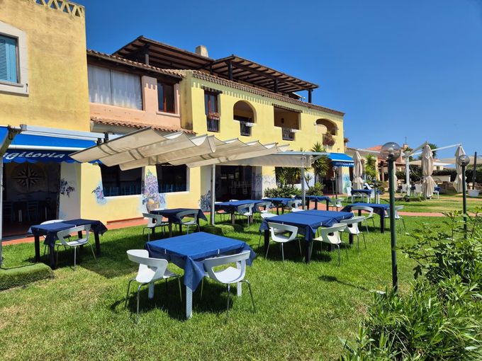 Tre grandi vassoi di pizza e frutti di mare con spicchi di limone su un tavolo