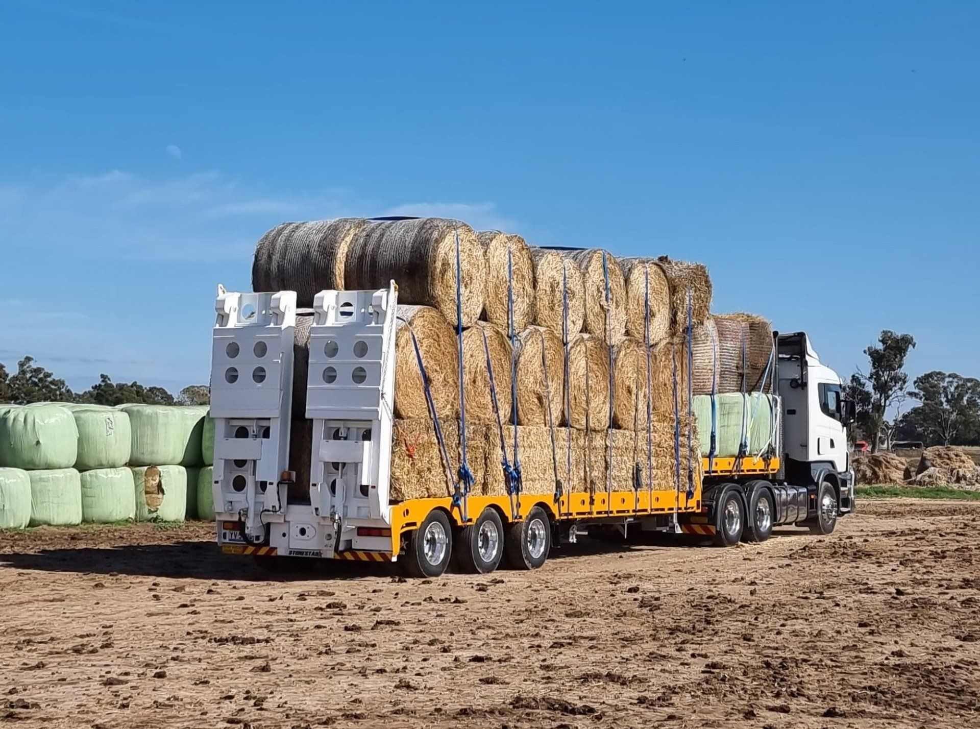 Hay bales loaded onto large truck, rear-facing