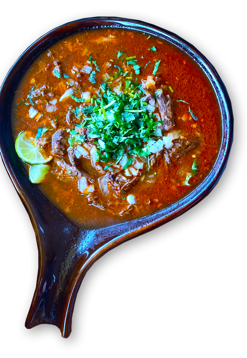 A bowl of soup with meat and cilantro on top