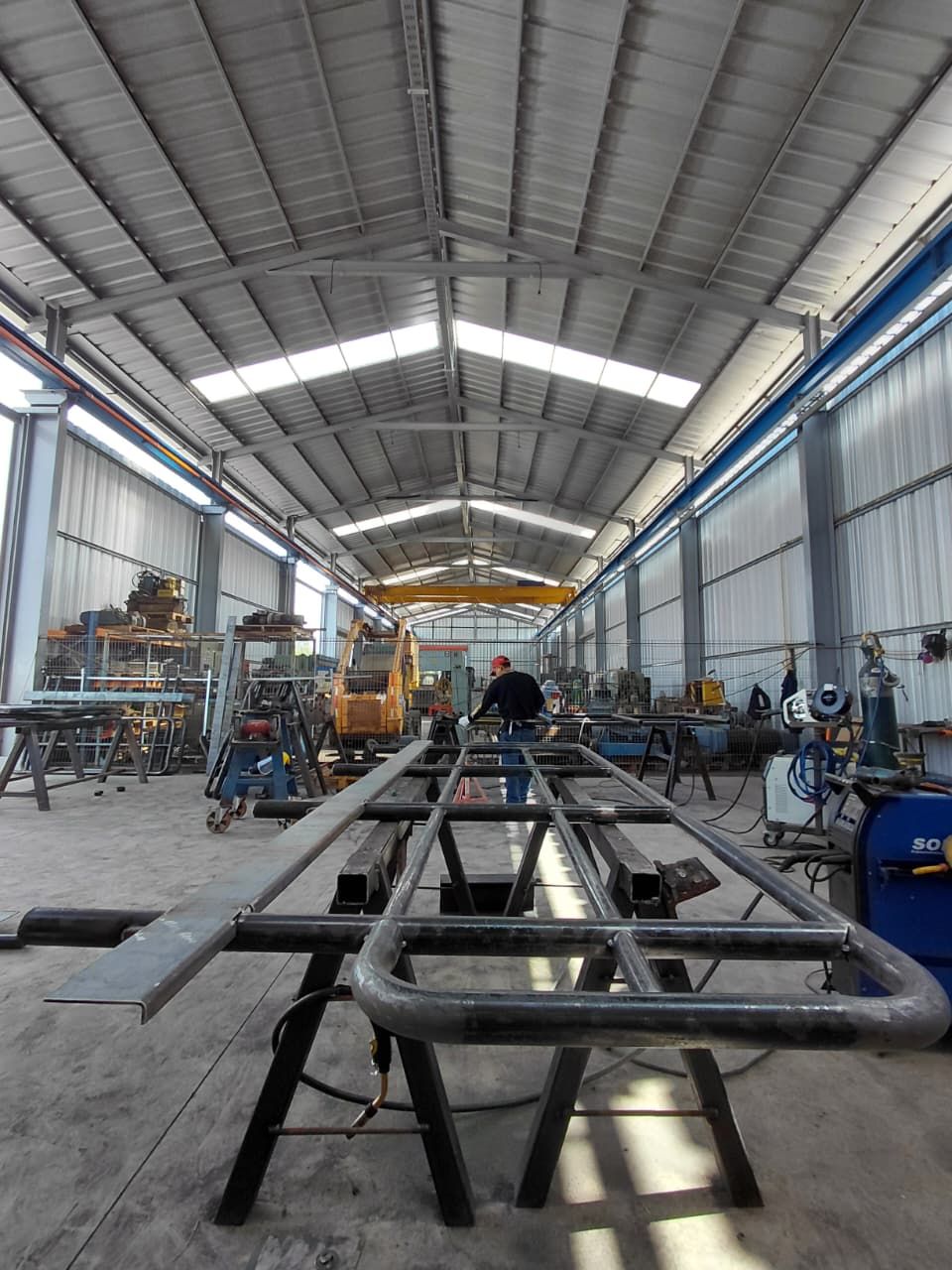 Dentro de un taller metalúrgico, una persona suelda