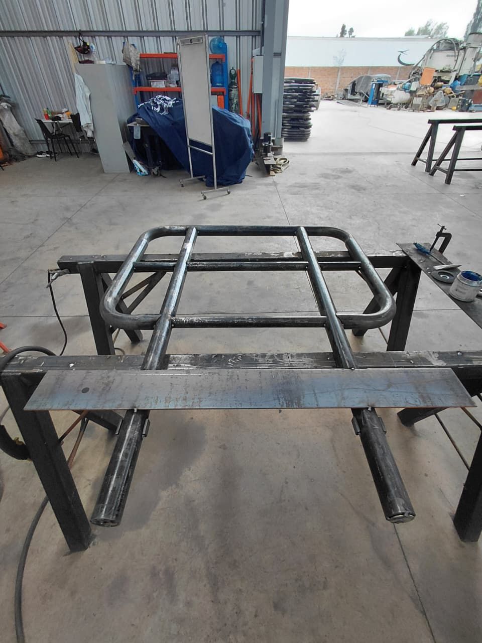 Estructura metálica soldada sobre un banco de trabajo en un taller.