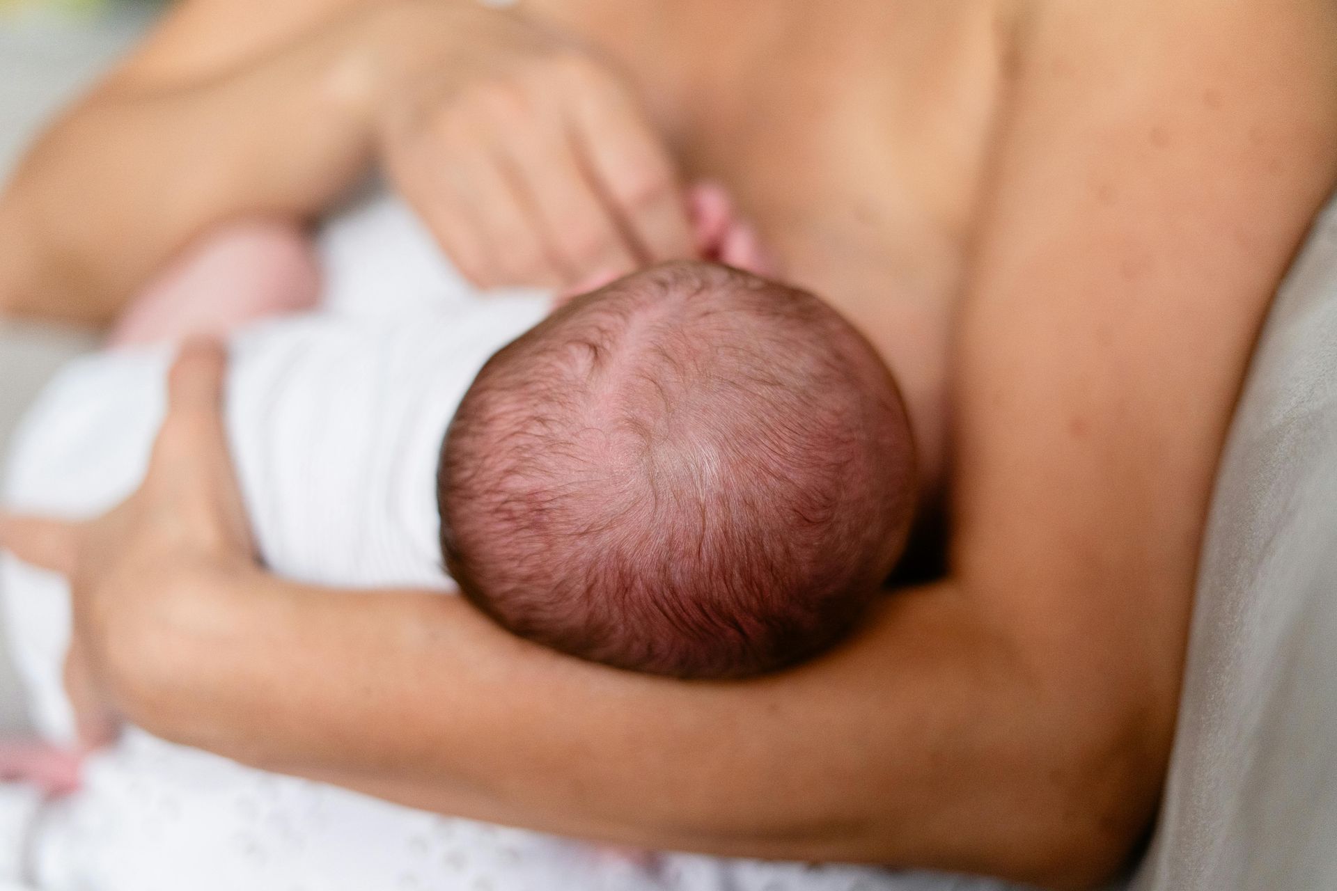 woman holding baby breastfeeding