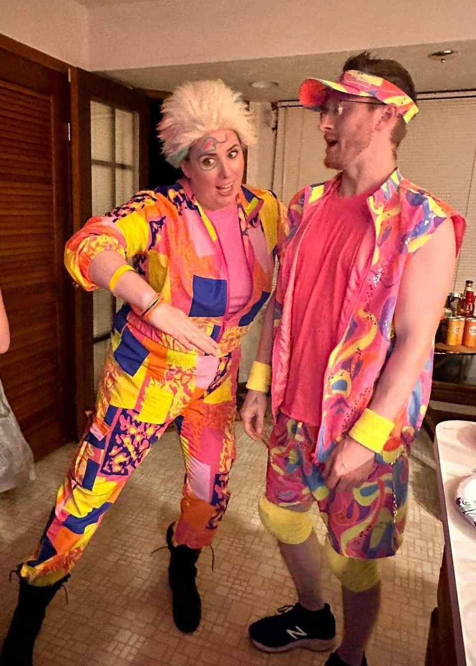 A man and a woman in colorful costumes are standing next to each other in a room.