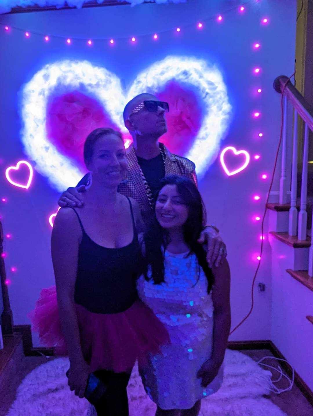 A group of people standing in front of a wall with hearts on it