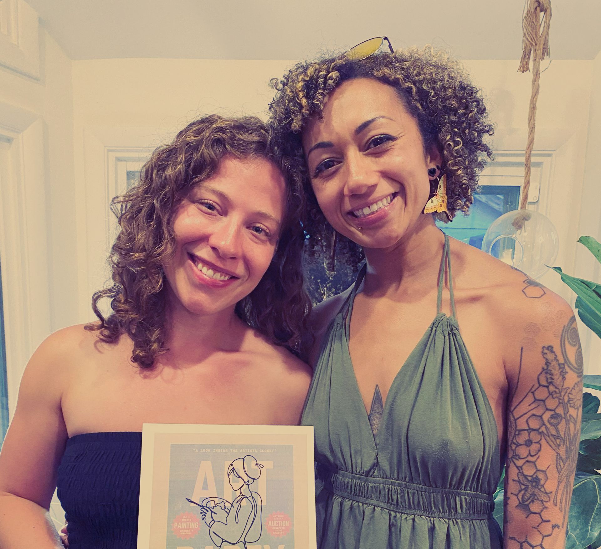 Two women are posing for a picture and one is holding alayna's