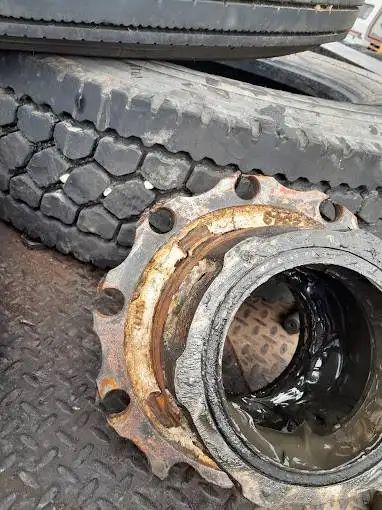 A close up of a wheel hub with a tire in the background.