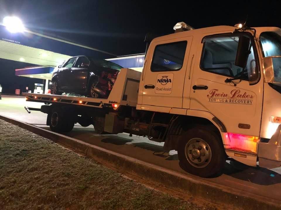 A Tow Truck with A Car on The Back Is Parked in Front of A Gas Station — Twin Lakes Towing & Recovery in Warners Bay, NSW