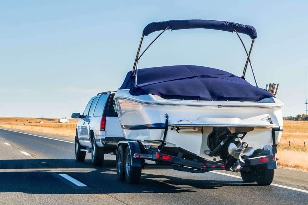 A Truck Is Towing a Boat Down a Highway — Twin Lakes Towing & Recovery in Sandgate, NSW