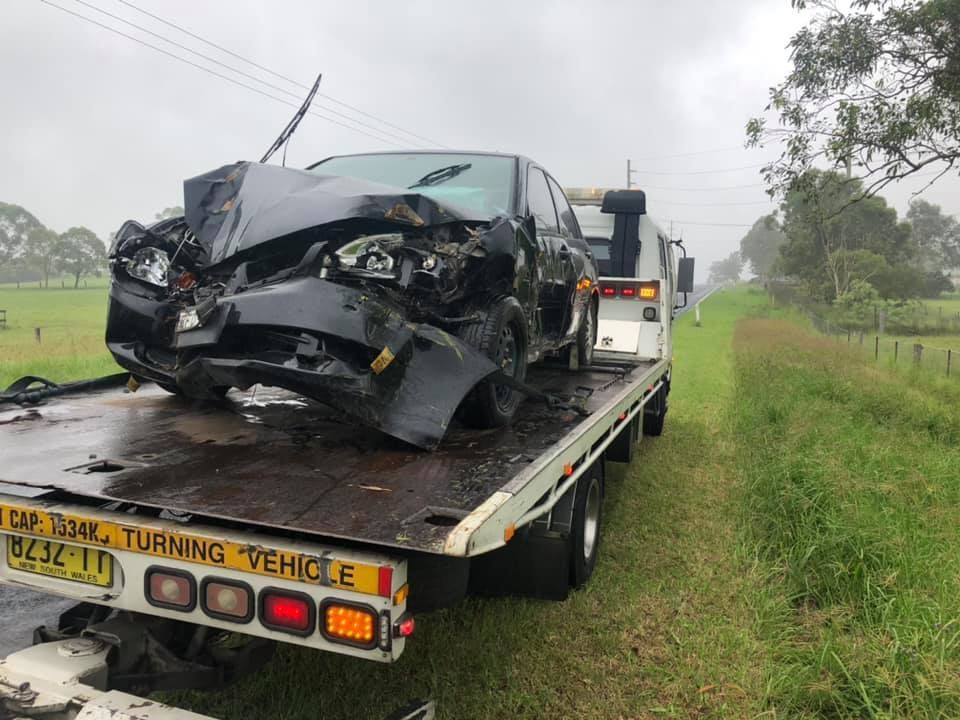 A Damaged Car Is Being Towed by A Tow Truck — Twin Lakes Towing & Recovery in Hamlyn Terrace, NSW