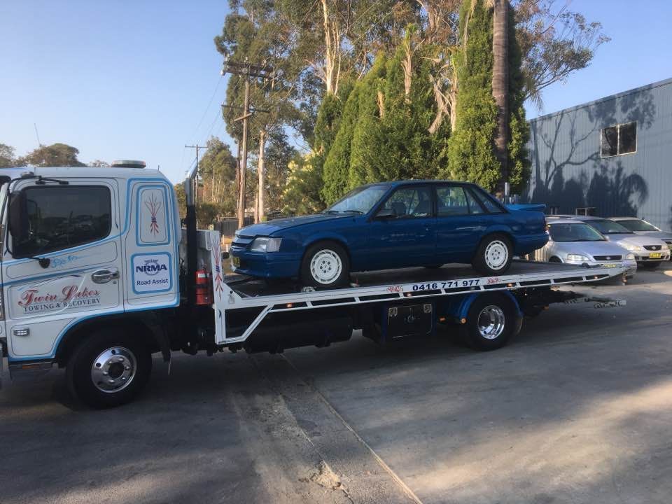 A Blue Car Is Being Towed by A Tow Truck — Twin Lakes Towing & Recovery in Tuggerah, NSW