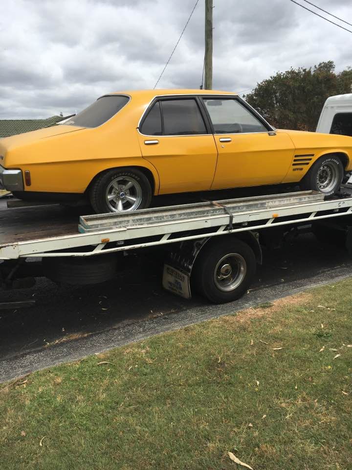 A Yellow Car Is Being Towed by A Tow Truck — Twin Lakes Towing & Recovery in Newcastle, NSW