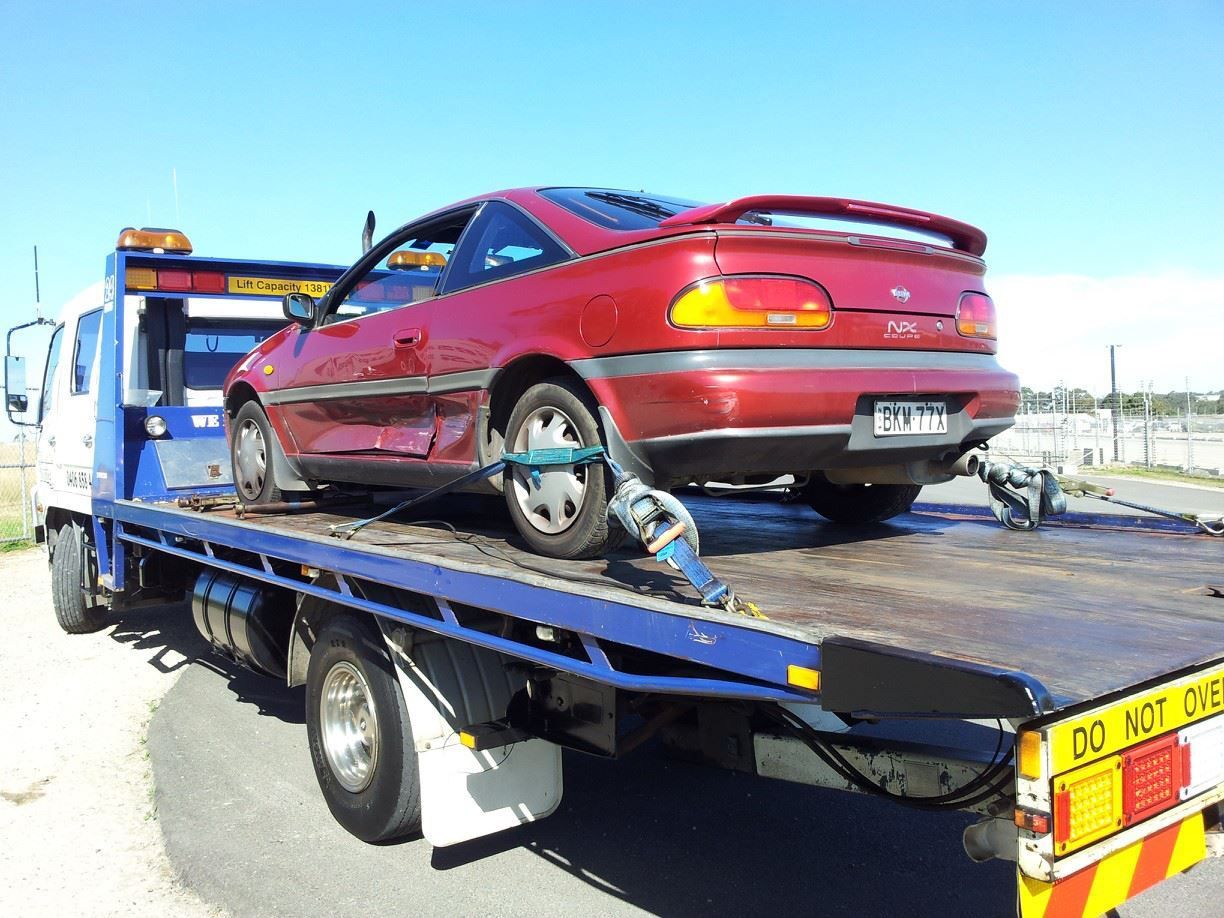 A Red Car Is on The Back of A Tow Truck — Twin Lakes Towing & Recovery in Cessnock, NSW