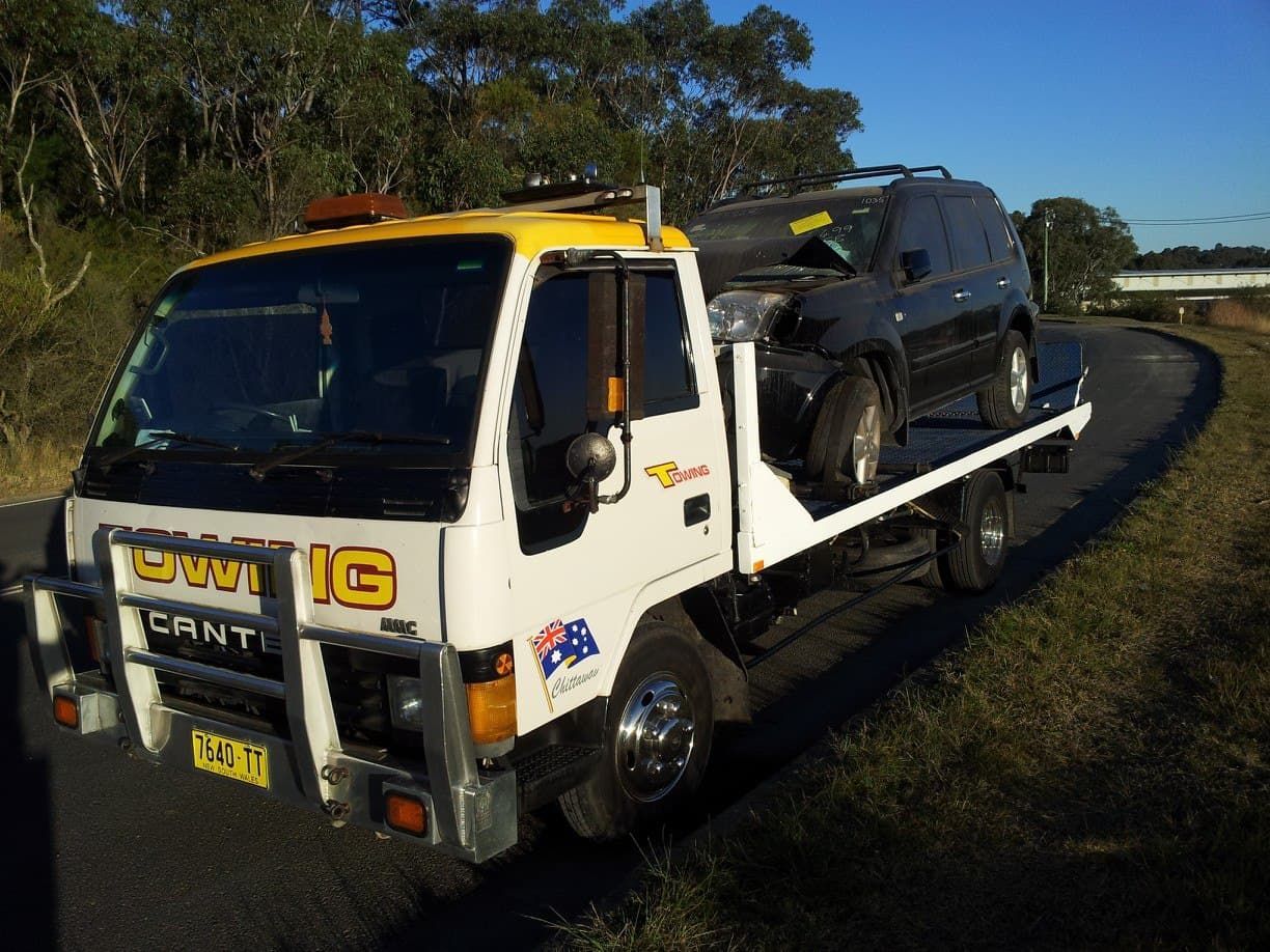 A White and Yellow Tow Truck Carrying a Black Suv — Twin Lakes Towing & Recovery in Budgewoi, NSW