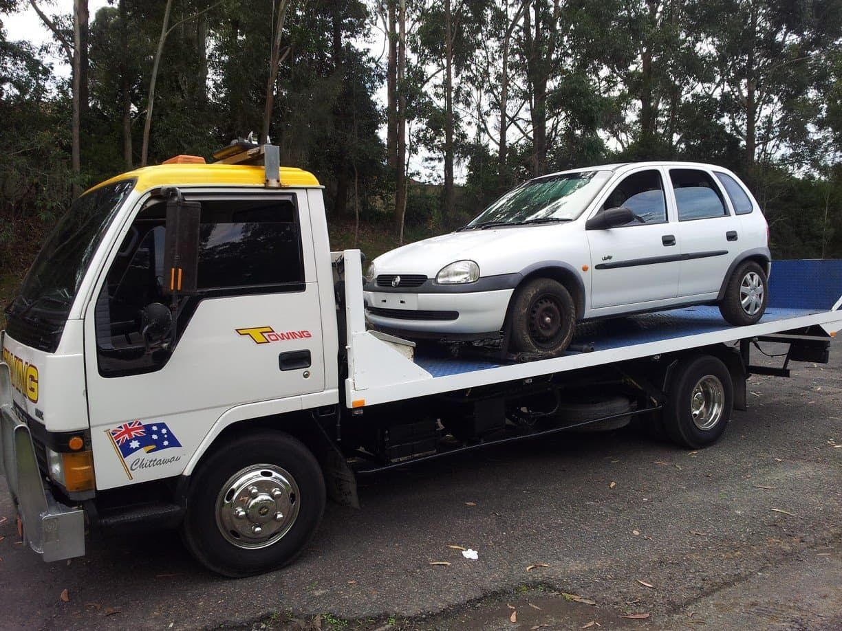 A White Car Is on The Back of A Tow Truck — Twin Lakes Towing & Recovery in Rutherford, NSW