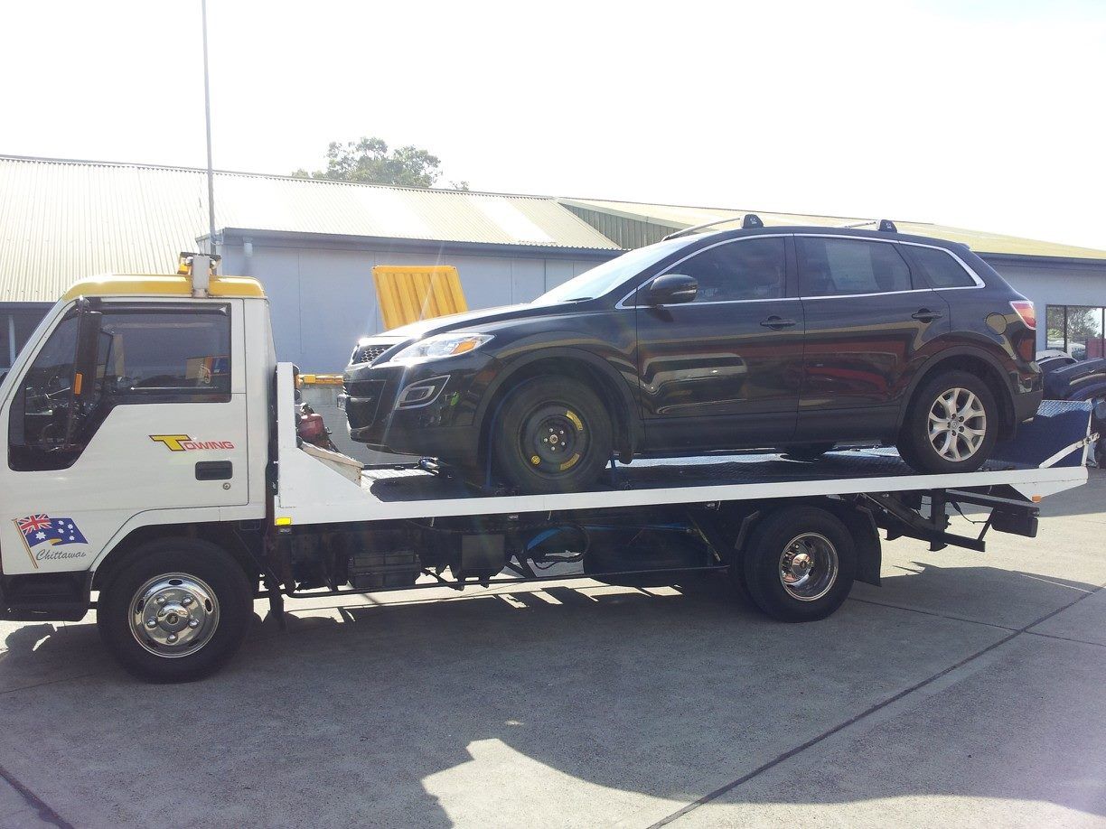 A Black Suv Is Being Towed by A Tow Truck — Twin Lakes Towing & Recovery in Wyong, NSW
