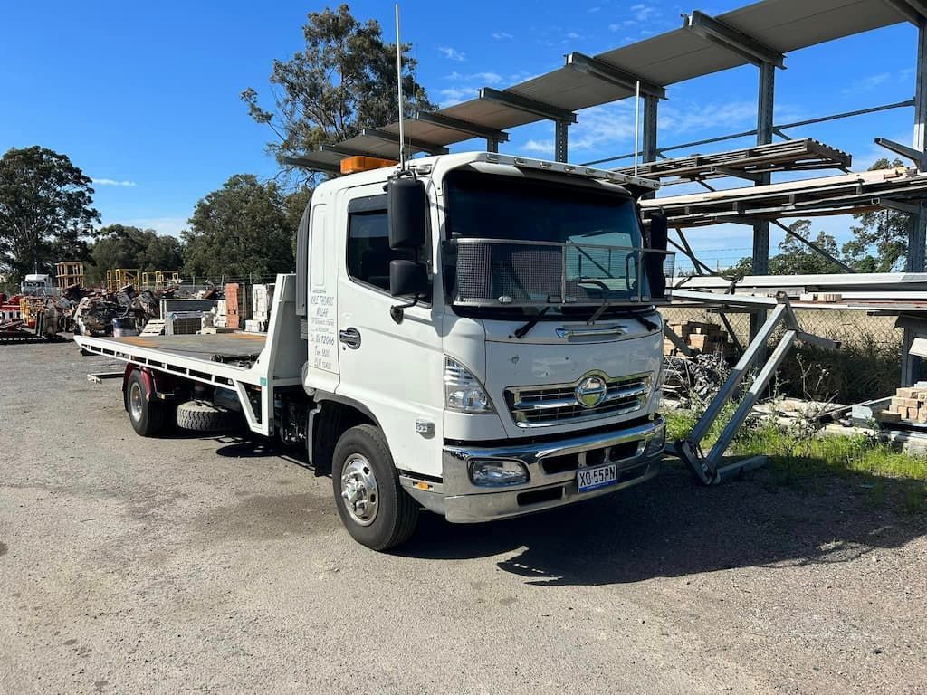 A White Flatbed Truck Is Parked in A Parking Lot — Twin Lakes Towing & Recovery in Toukley, NSW