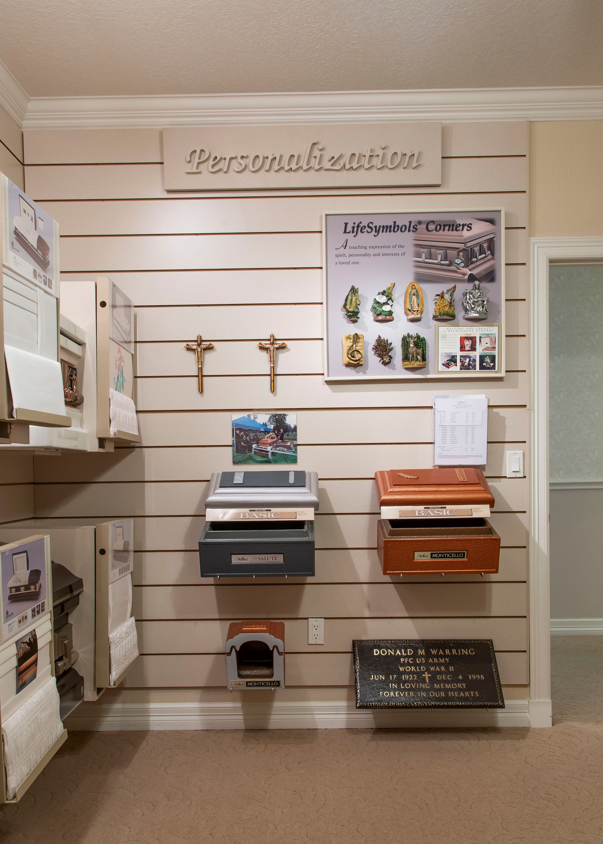 Wall display with personalization options, including urns, crosses, and sample photos.