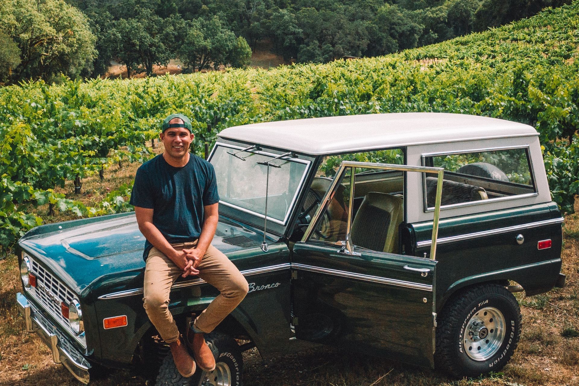 Josh Phelps sitting atop his Ford Bronco in the vineyard