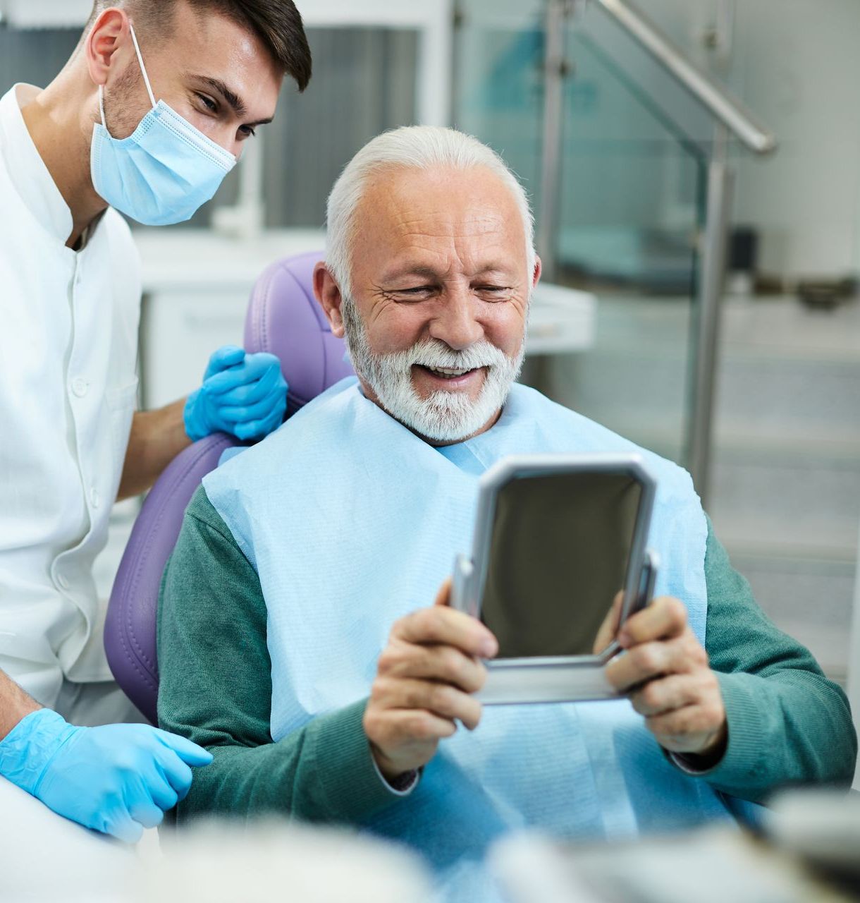 RESTORATIVE DENTISTRY | old man smiling in mirror at dental office | Veneers, implants, dentures