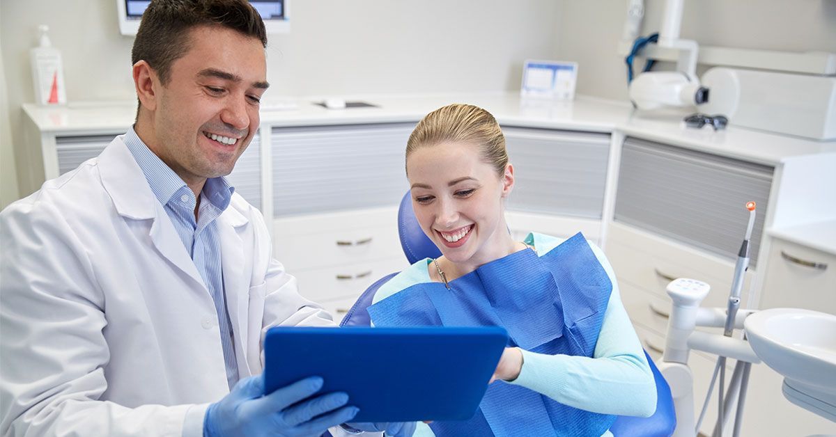 Patient Specials | Dentist Smiling and Showing Chart to Smiling Patient | Garland TX 75040