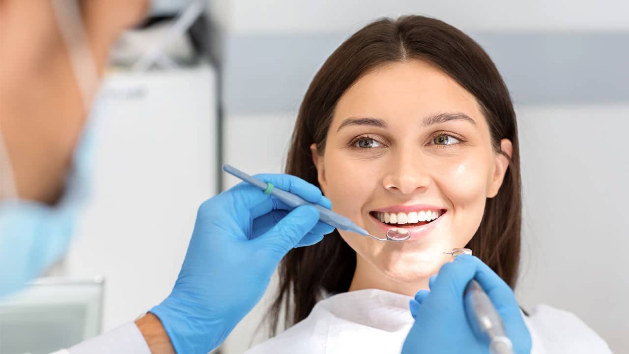 woman smiling at dentist | dental implants in Garland TX 75040