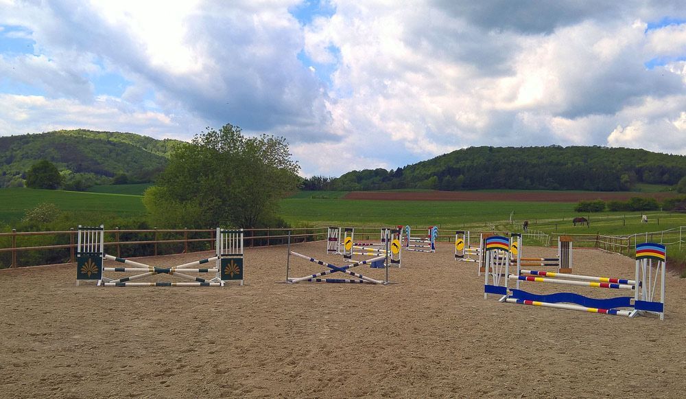 A Row Of Jumping Fences In A Dirt Field With Mountains In The Background — East Point Earthmoving in Byron Bay, NSW