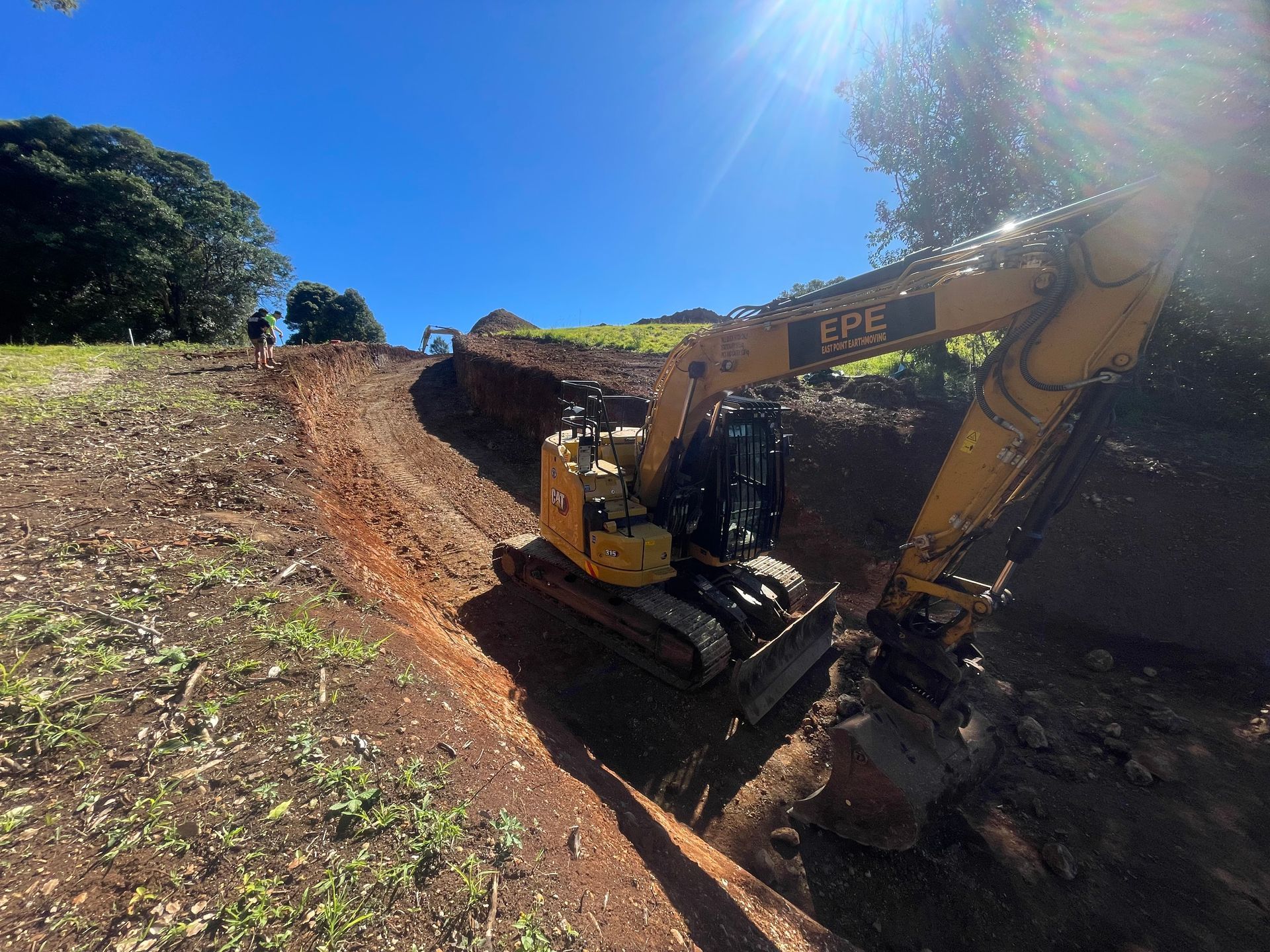A Yellow Excavator Is Demolishing A Building On A Construction Site — East Point Earthmoving in Byron Bay, NSW