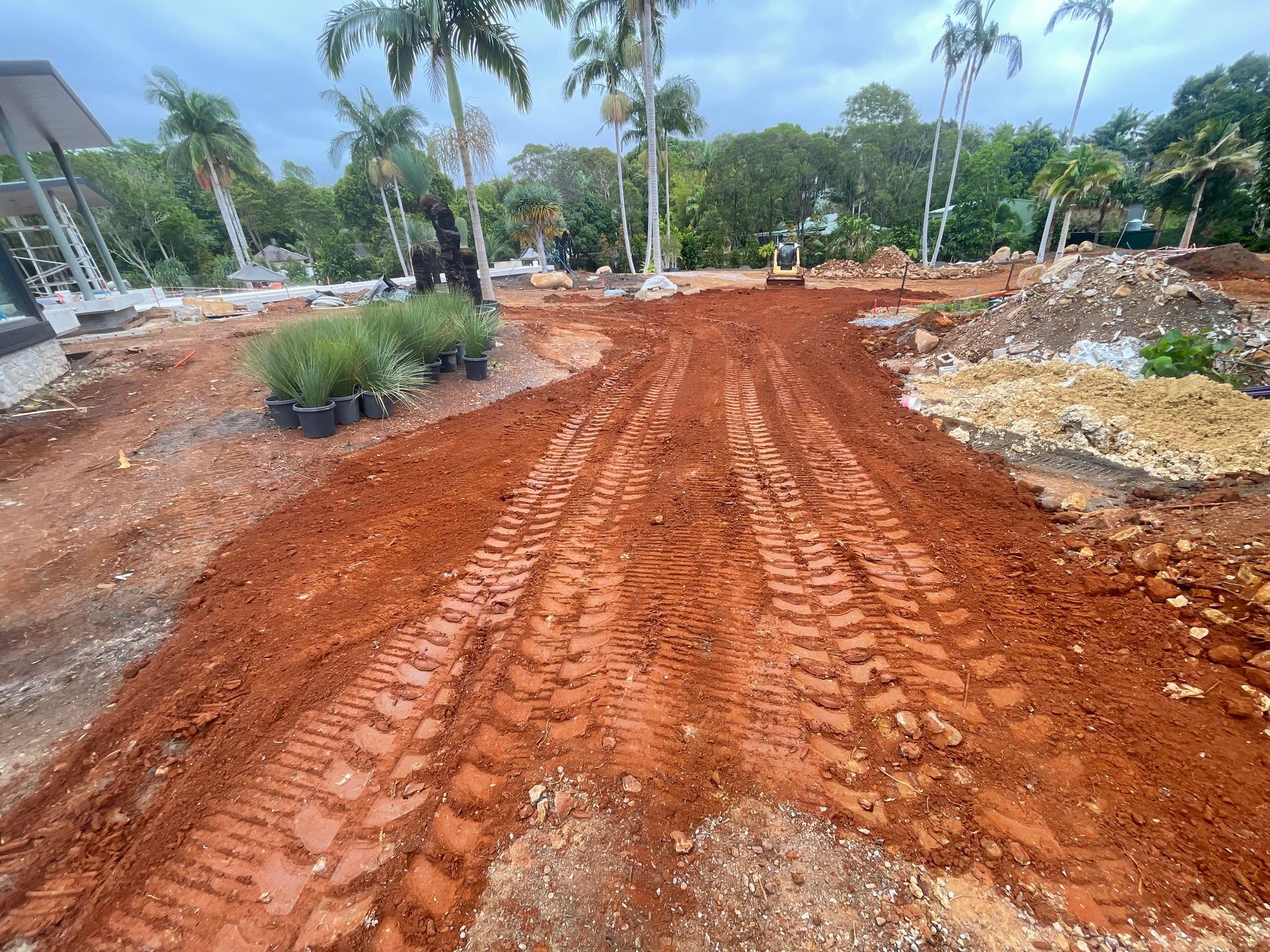 A Yellow Excavator Is Digging A Pile Of Dirt On A Construction Site — East Point Earthmoving in Byron Bay, NSW