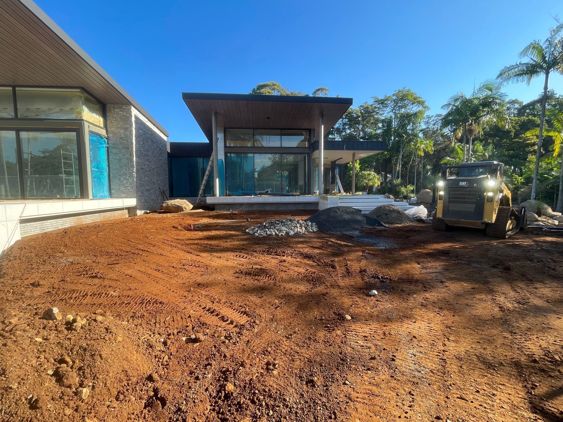 An Orange And Black Excavator Is Digging A Hole In The Dirt — East Point Earthmoving in Byron Bay, NSW