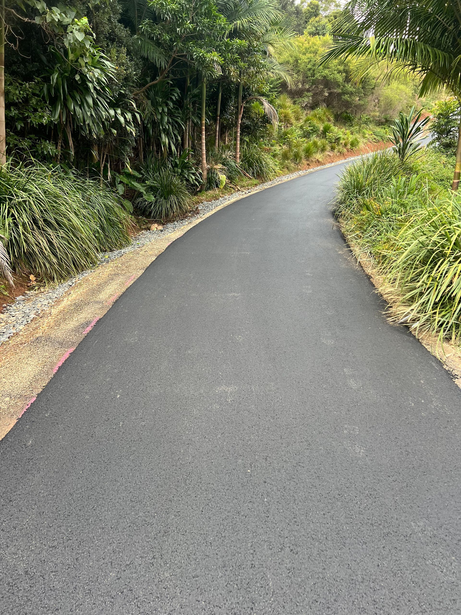A Yellow Excavator Is Digging A Hole In A Dirt Field — East Point Earthmoving in Byron Bay, NSW