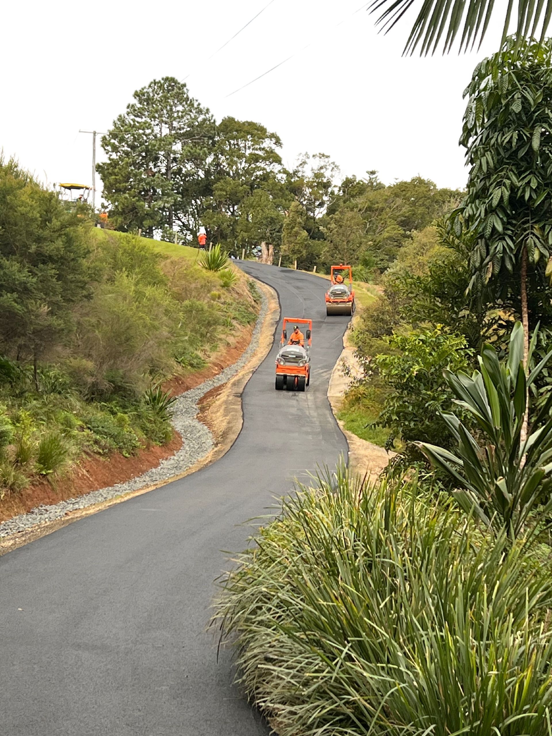 Two Orange Bulldozers Lay An Asphalt Road — East Point Earthmoving in Byron Bay, NSW