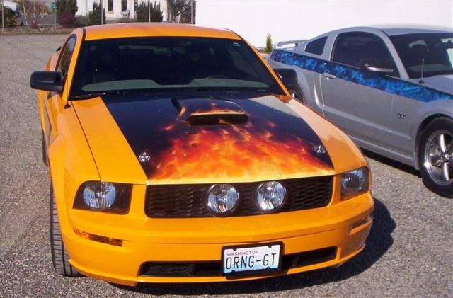 A yellow car with a license plate that says orng-gt