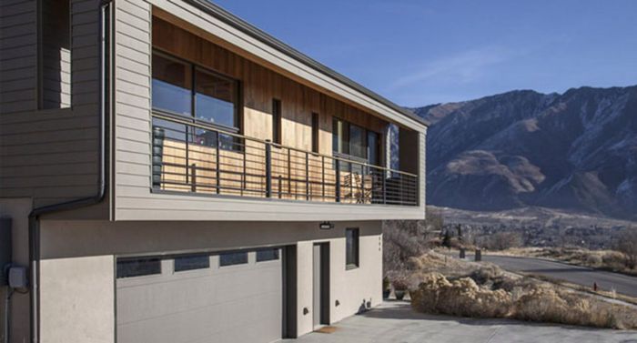 a modern house with a balcony and mountains in the background .