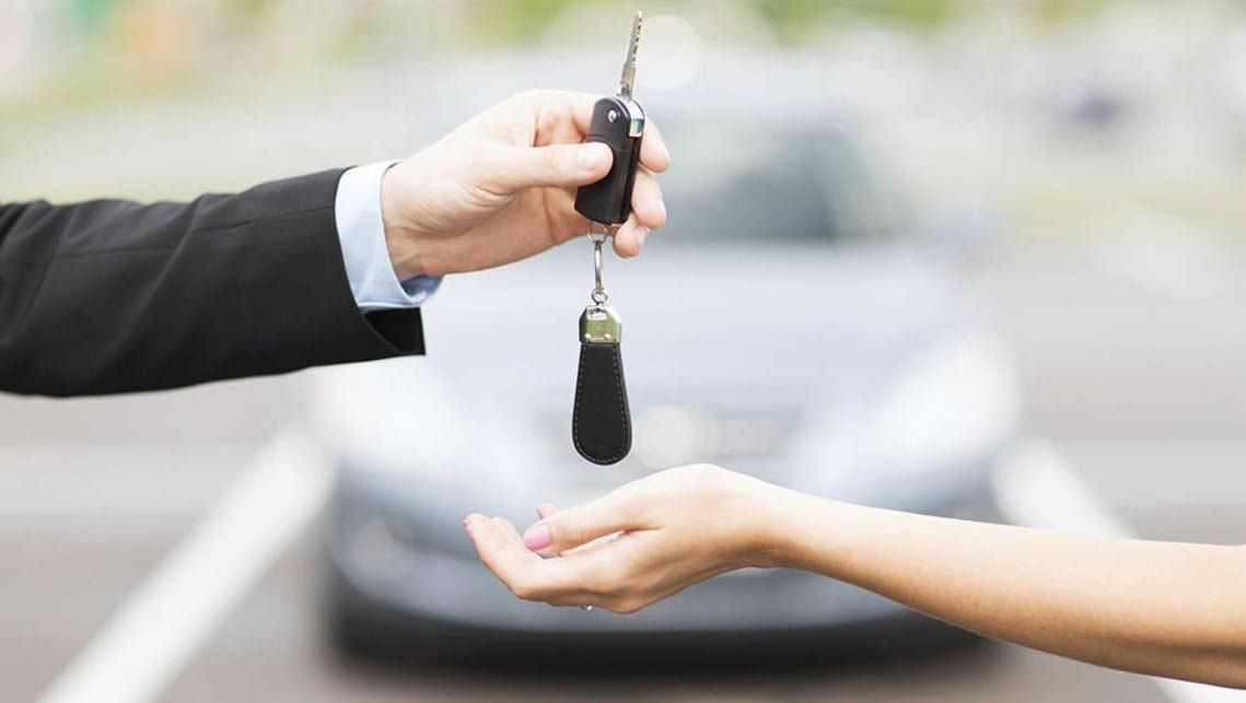 A man giving the car key — Barboursville, WV — Fast Tags Auto Title Service