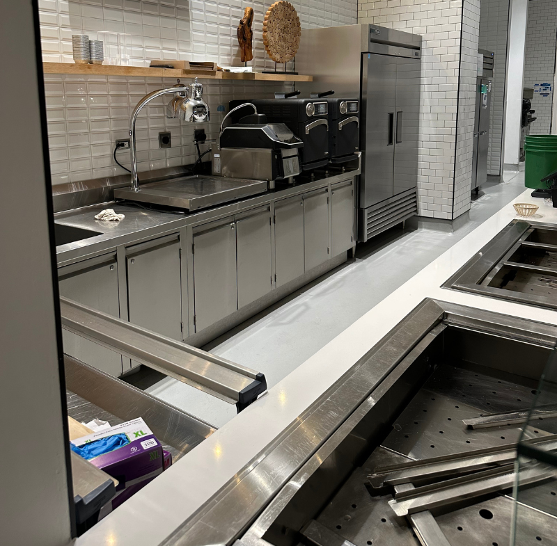 A kitchen with stainless steel cabinets and a flat screen tv on the wall cleared for a deep kitchen cleaning