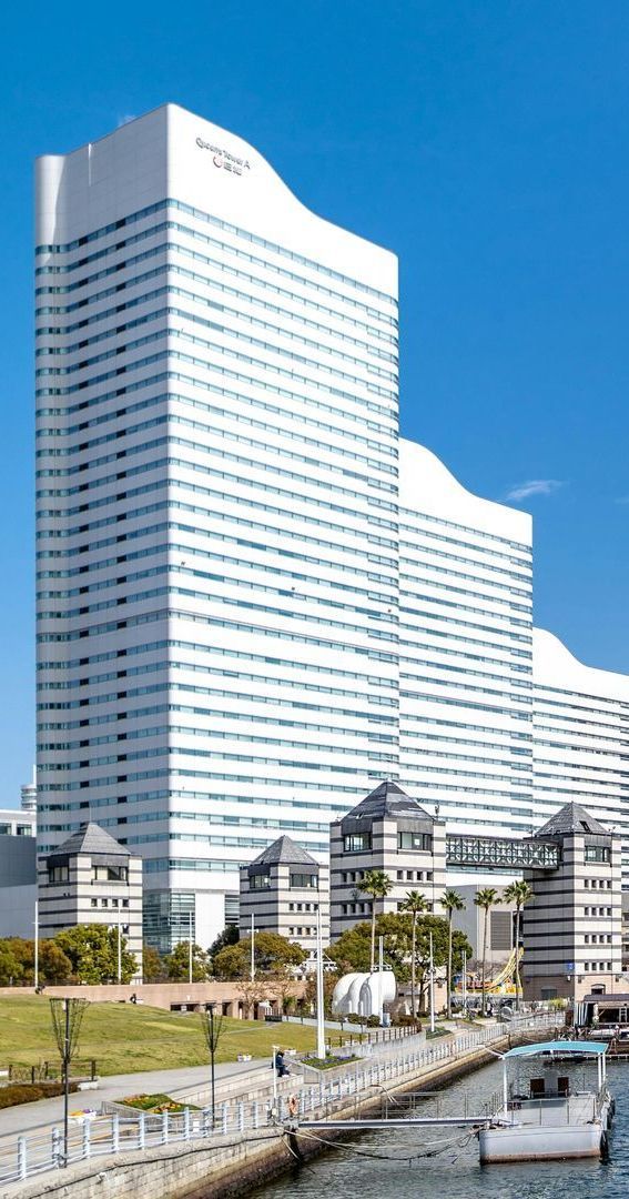 A tall building with palm trees in front of it.