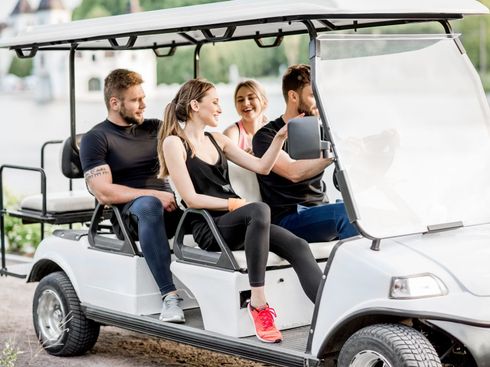 A group of people are sitting in a golf cart.