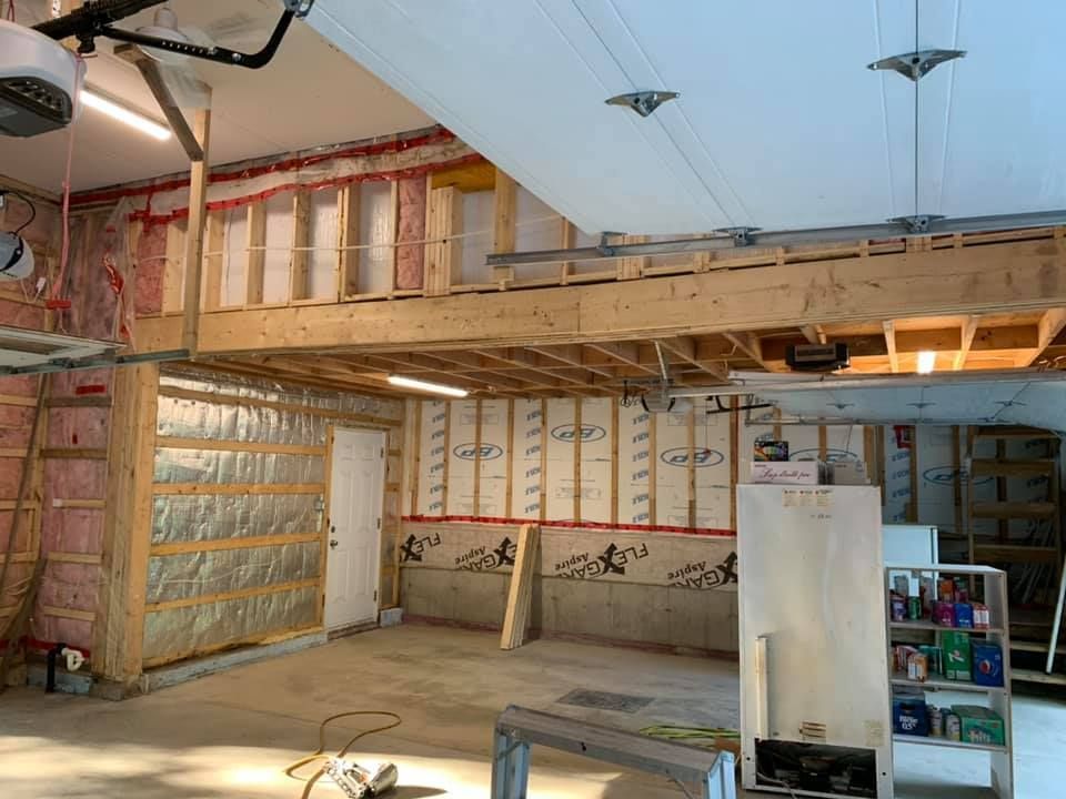 L'intérieur d'un garage en construction avec une échelle suspendue au plafond.