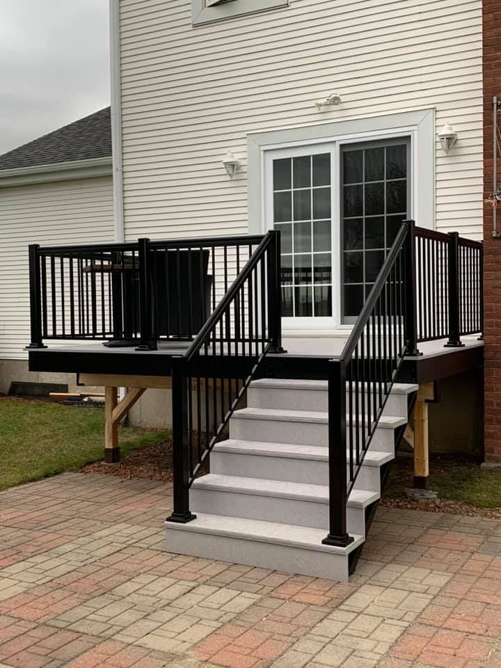 Une terrasse avec des escaliers qui y mènent se trouve devant une maison.