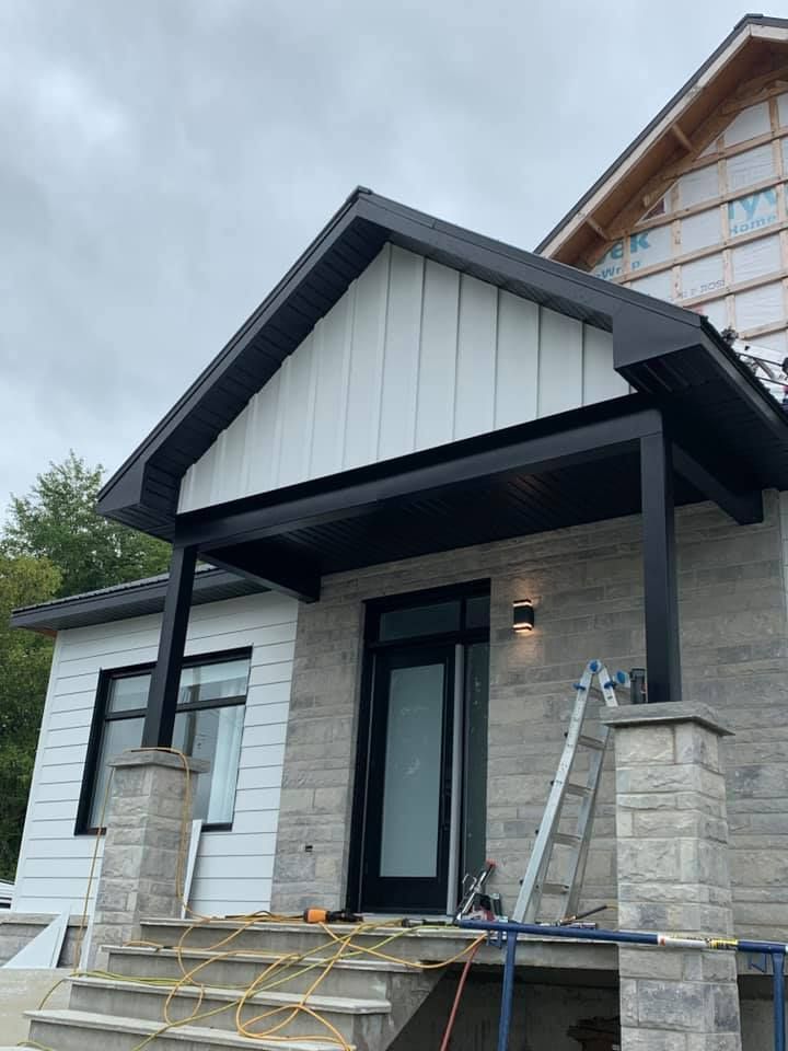 Une maison en construction avec un porche et des escaliers.