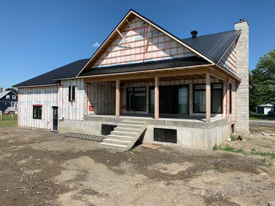 Une maison en construction avec un porche et des escaliers