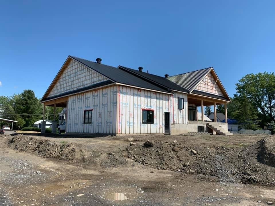Une maison est en construction au sommet d'une colline de terre.