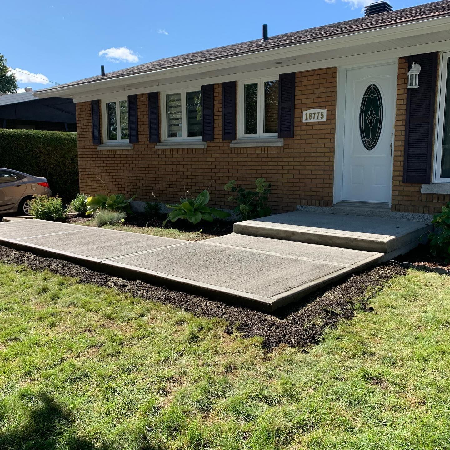 Une maison en briques avec une voiture garée devant