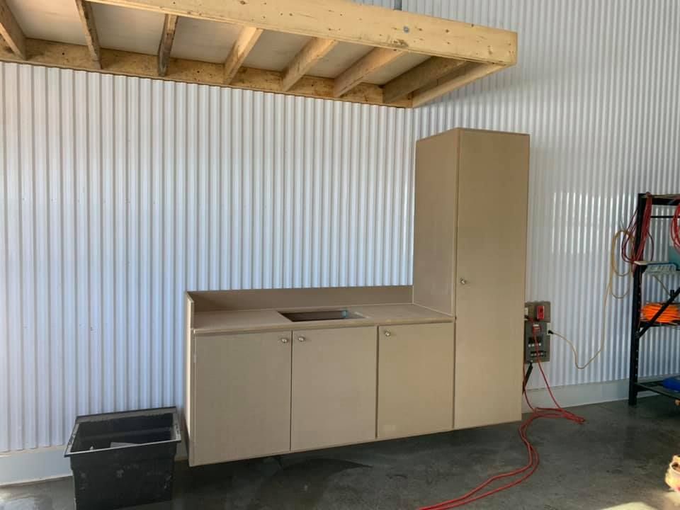 Une cuisine avec un évier et des armoires dans un garage.