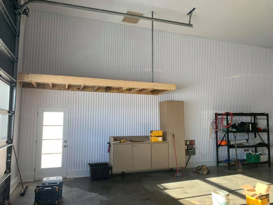 Un garage avec un ventilateur de plafond et une étagère.