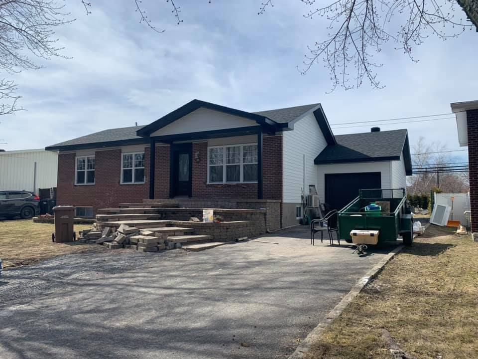 Une maison en briques avec un toit noir est en cours de rénovation.