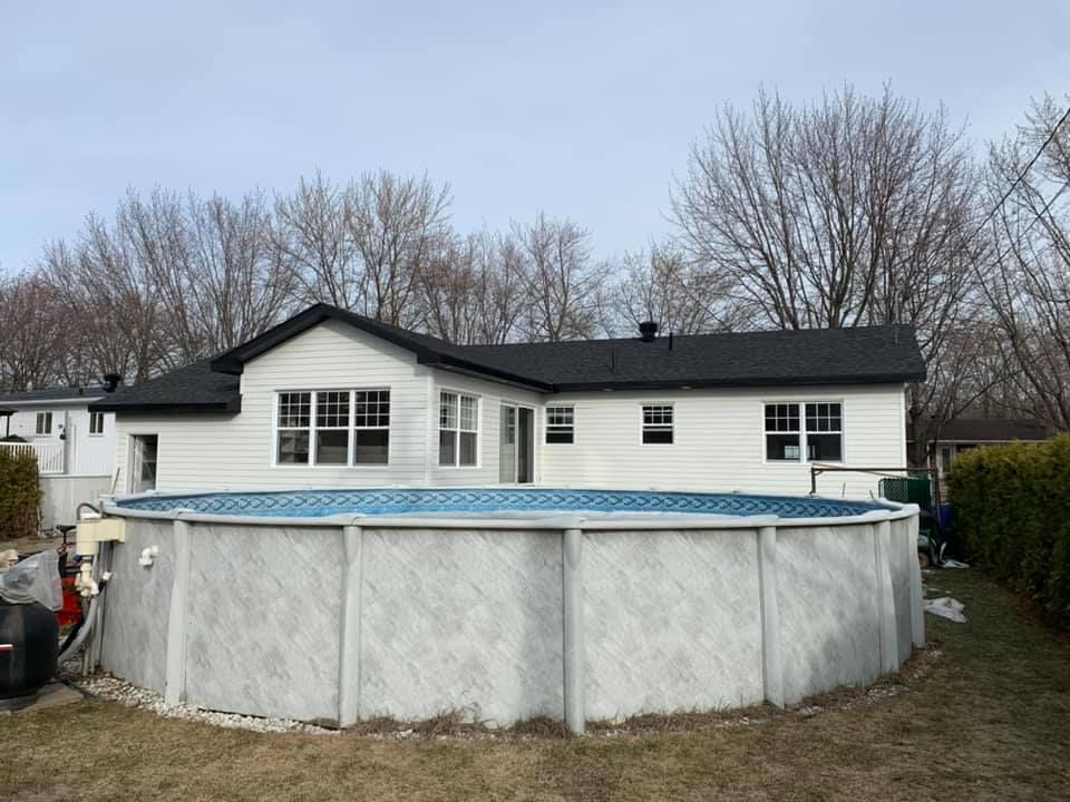 Une grande piscine se trouve dans l'arrière-cour d'une maison.