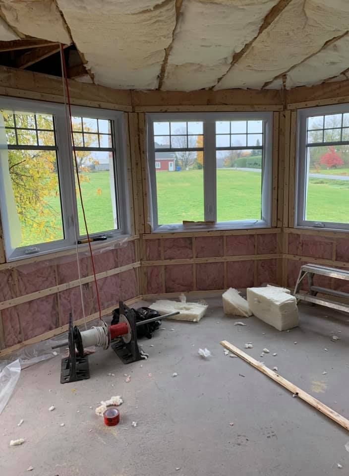 Une pièce avec beaucoup de fenêtres et d'isolation sur les murs.