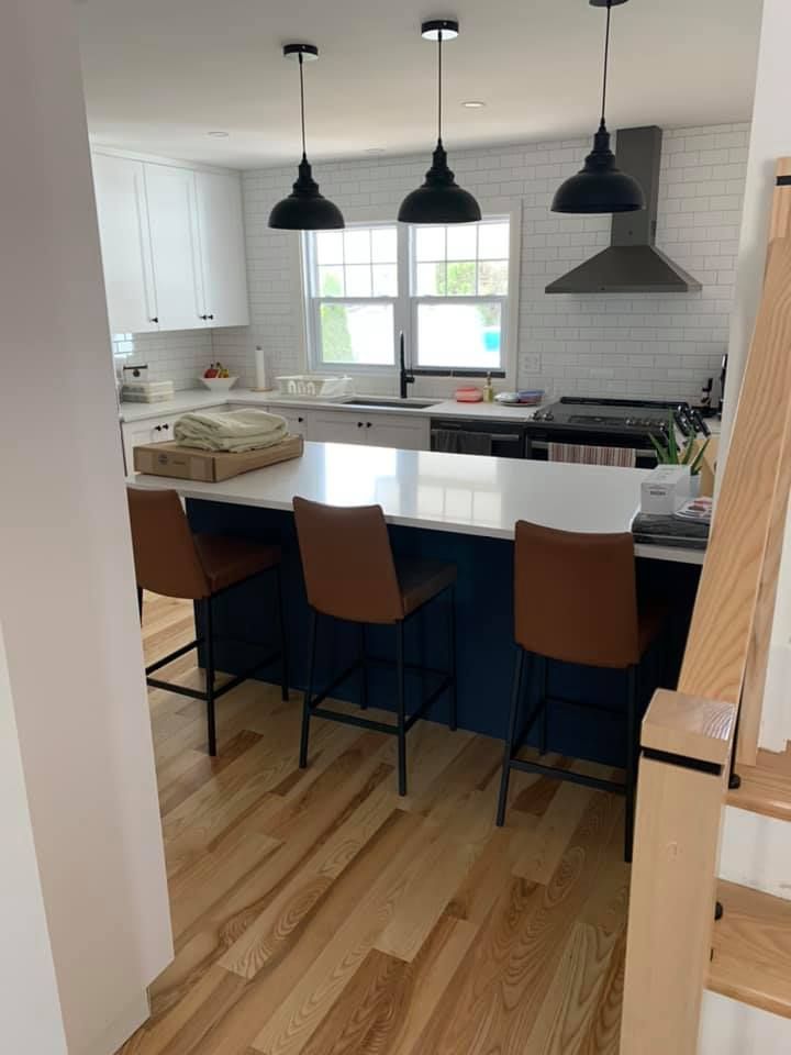 Une cuisine avec un îlot bleu et des chaises marron